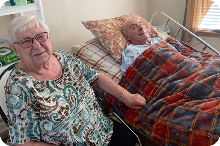 Sharon sitting next to Hilmer in his hospital bed.