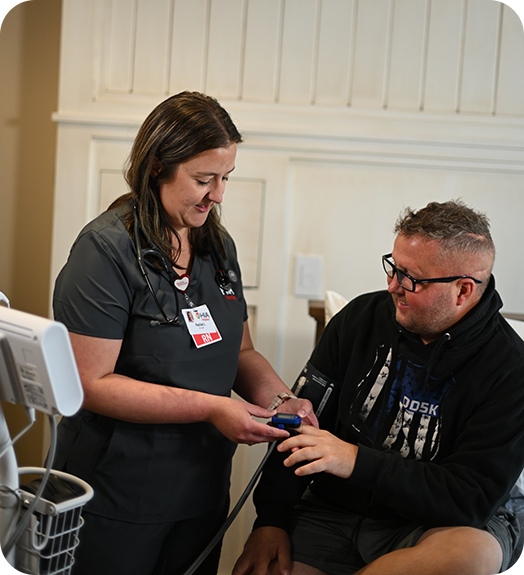 A nurse with Brad Schenck at HIA Heather's House taking his vitals.